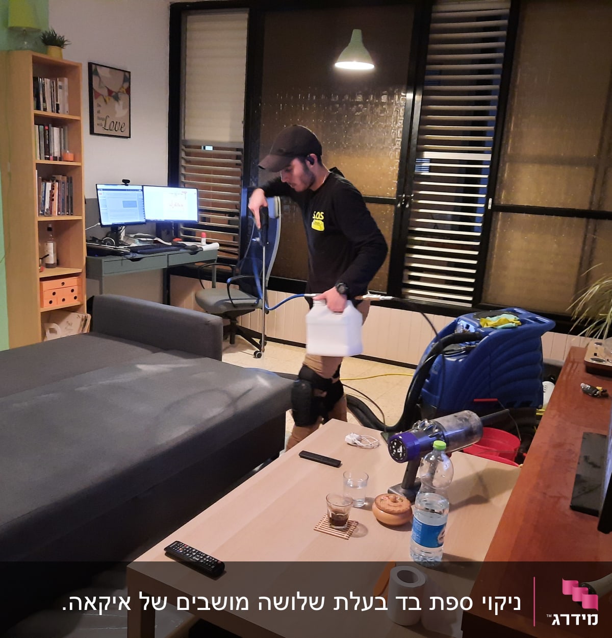 אדם מנקה ספה עם מכונת ניקוי ומיכל מים